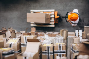Heart of the Customer's blog: How Do I Get Distribution Executives to Care About CX? Image shows a birds-eye view of a person with an orange helmet working in a warehouse.